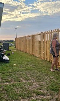 a woman standing next to an rv in a grassy area